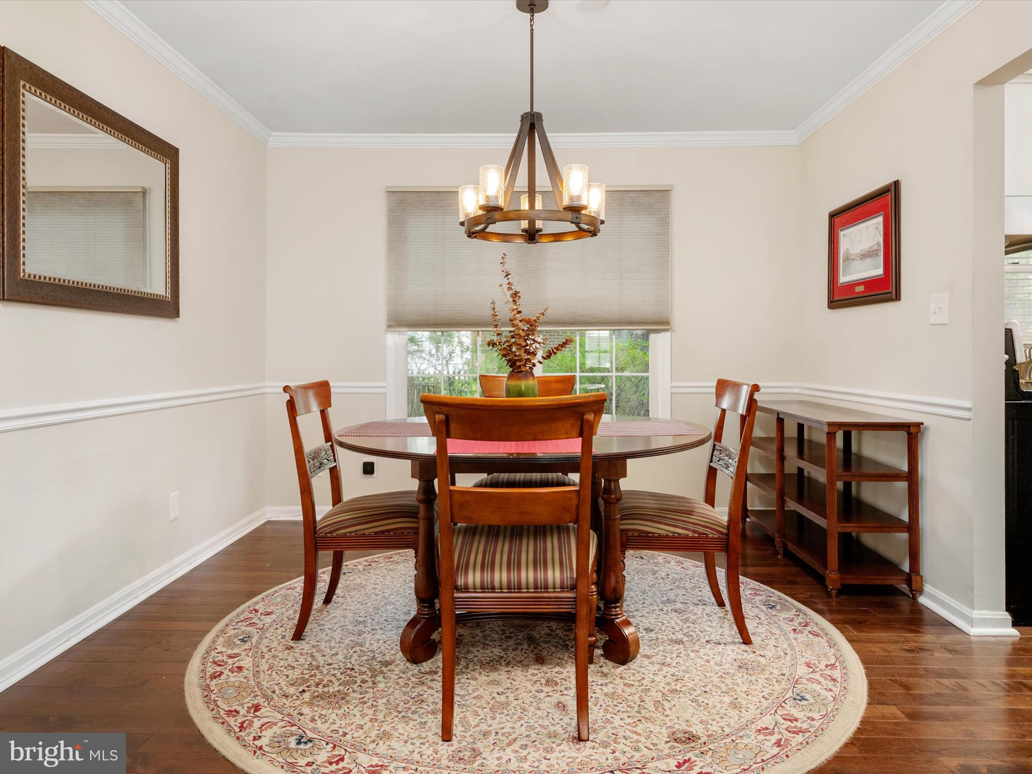 1711 Peartree Lane Crofton, MD 21114 - Photo 13 of 65 a dining room with wooden floor a chandelier a wooden table and chairs