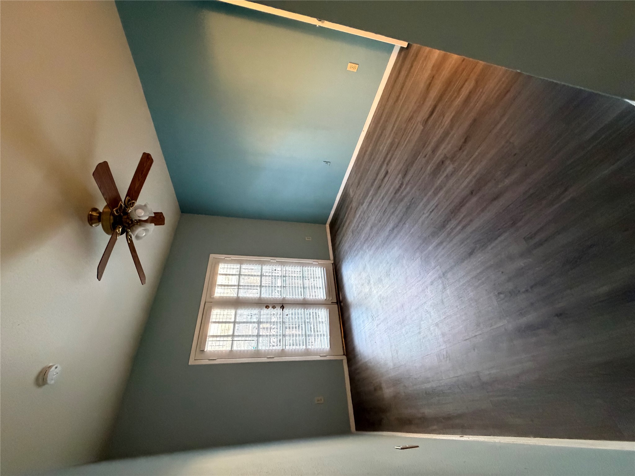 2801 Rio Grande Street, Unit 208 Austin, TX 78705 - Photo 4 of 8 French doors lead to a sun-drenched interior featuring plank flooring and a classic ceiling fan.
