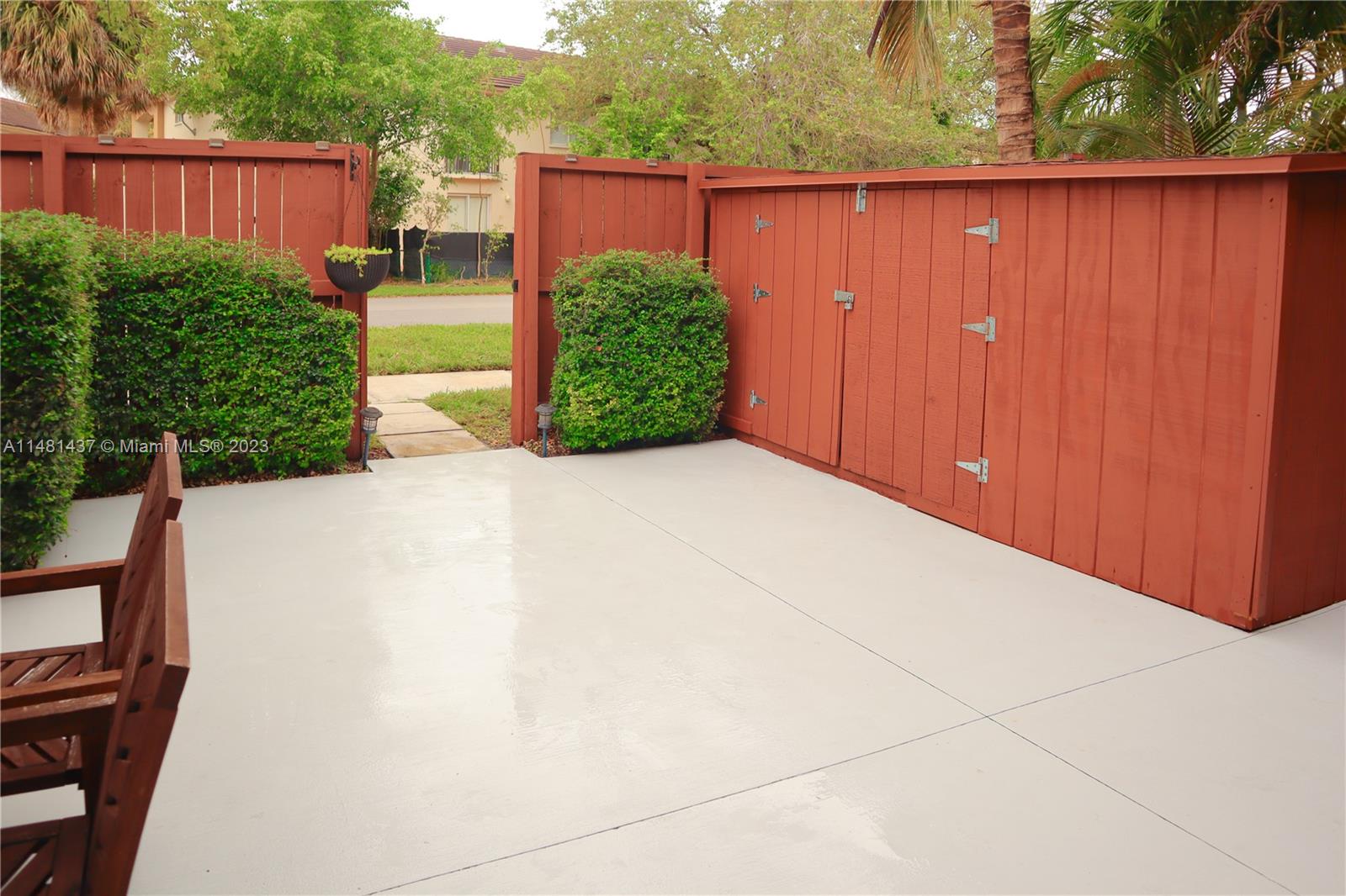 6704 Southwest 114th Place, Unit E Miami, FL 33173 - Photo 24 of 34 a view of backyard with potted plants and wooden fence