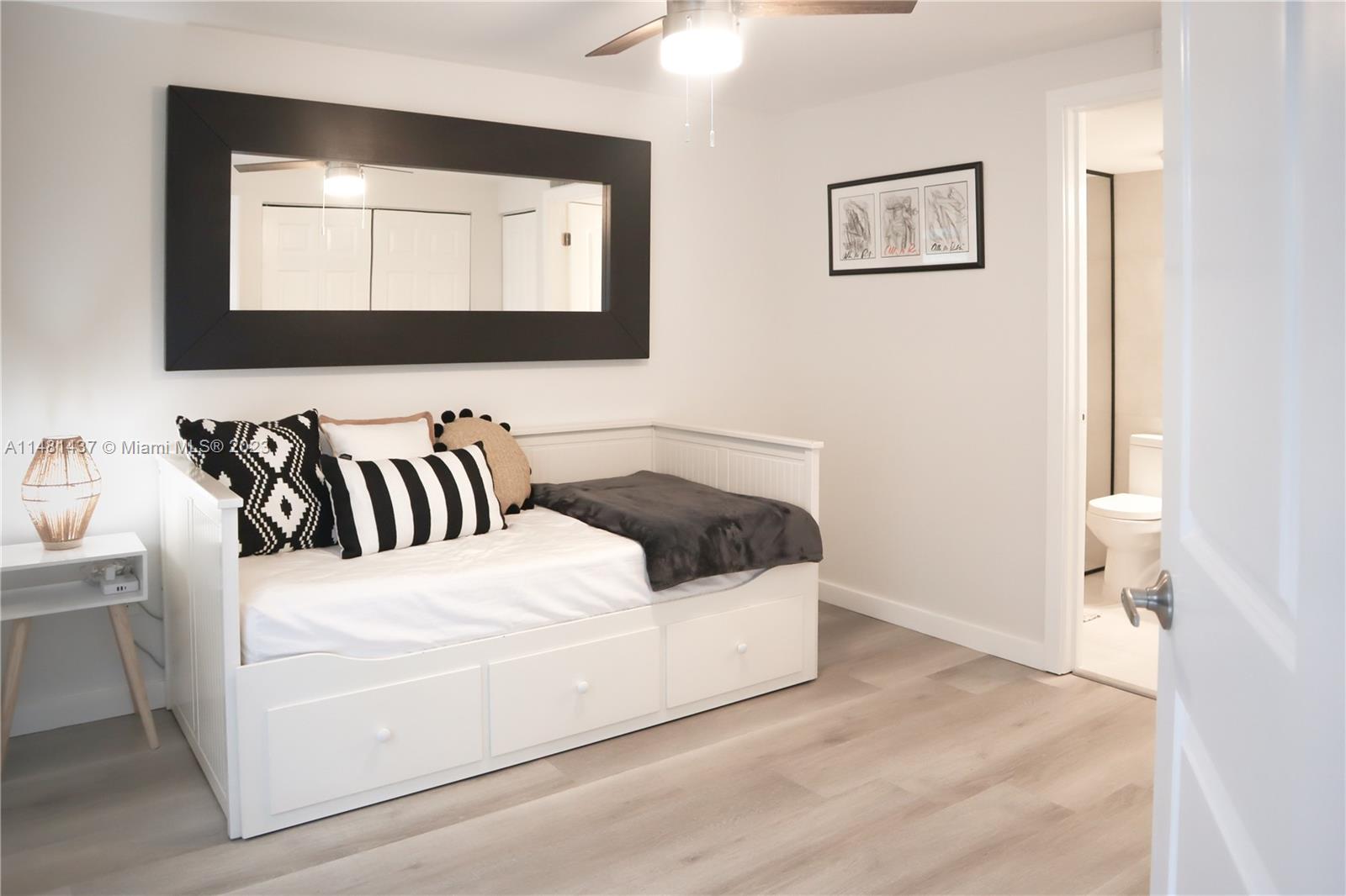 6704 Southwest 114th Place, Unit E Miami, FL 33173 - Photo 28 of 34 a white bed sitting in a bathroom next to a window