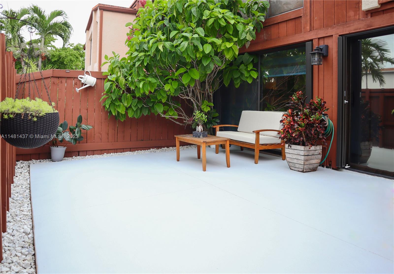 6704 Southwest 114th Place, Unit E Miami, FL 33173 - Photo 32 of 34 a wooden bench sitting in front of a building