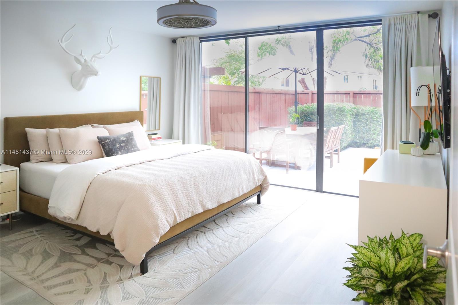 6704 Southwest 114th Place, Unit E Miami, FL 33173 - Photo 8 of 34 a bedroom with a large bed and a large window