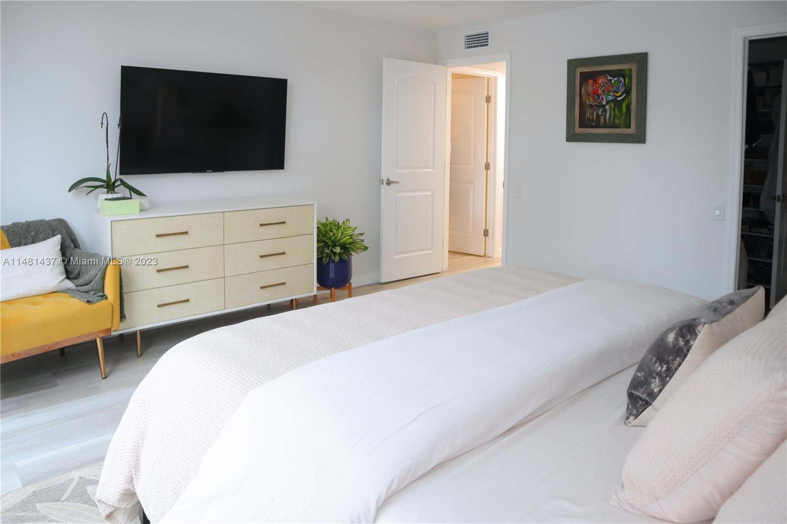 6704 Southwest 114th Place, Unit E Miami, FL 33173 - Photo 9 of 34 a bedroom with a bed and a flat screen tv