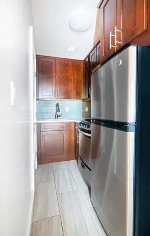 a kitchen with granite countertop a refrigerator and a sink