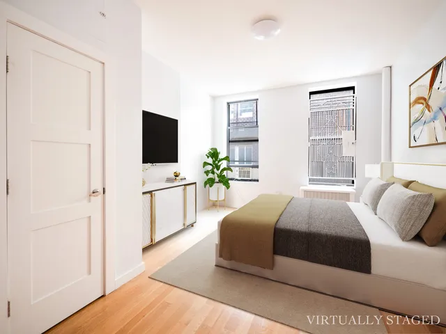 a bedroom with a large bed and a flat screen tv