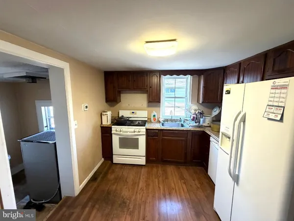 a kitchen with granite countertop a refrigerator and a stove top oven
