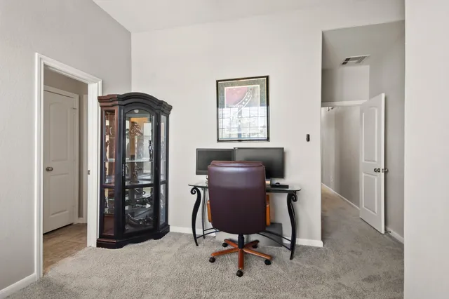 a view of a workspace with furniture and a window