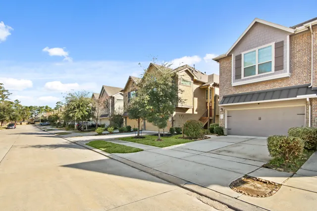 a view of a white house with a yard and road