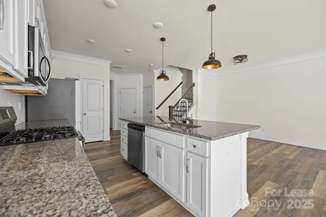 a kitchen with stainless steel appliances granite countertop a sink stove and cabinets