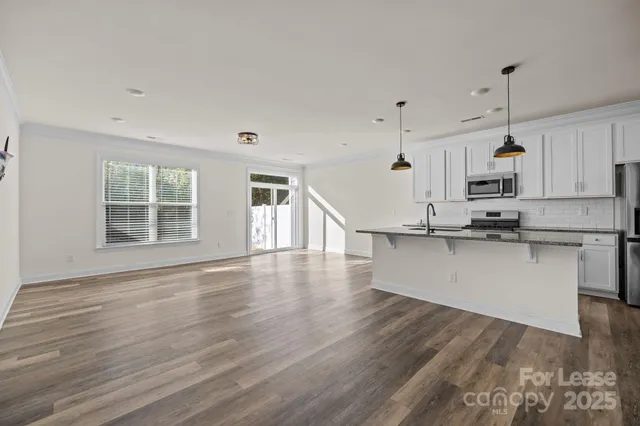 a view of a kitchen with wooden floor and window