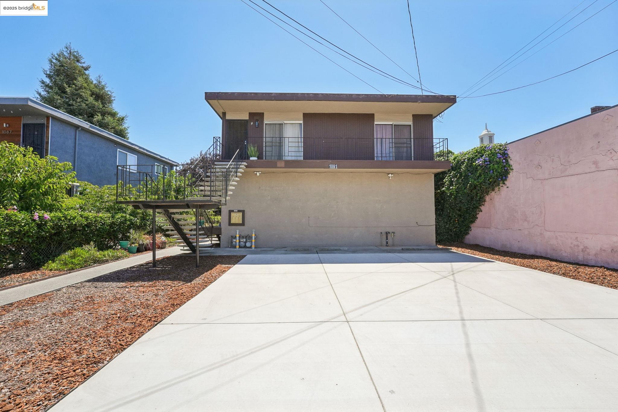 View of front featuring stairs, balcony, Unit C entry, and parking