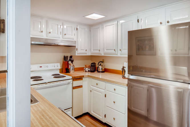 345 N Road Chilmark, MA 02535 - Photo 12 of 26 a kitchen with stainless steel appliances granite countertop a refrigerator sink and white cabinets