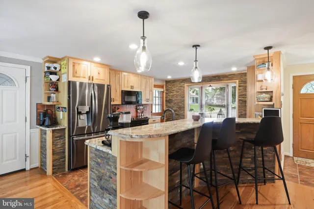 a kitchen with stainless steel appliances kitchen island granite countertop a refrigerator and microwave
