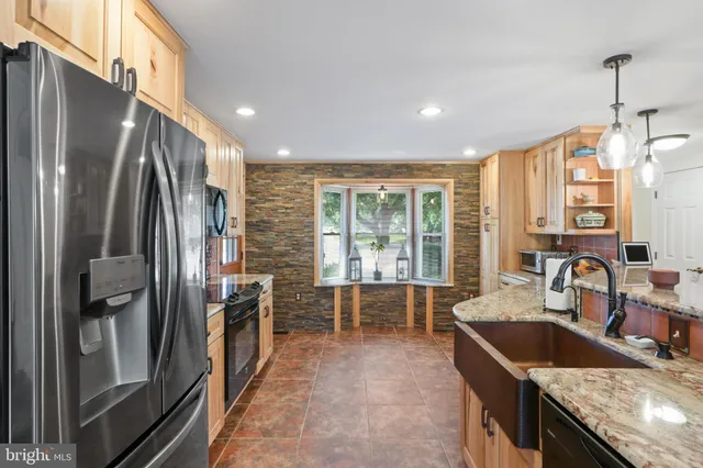 a kitchen with kitchen island a large counter top space a sink stainless steel appliances and cabinets