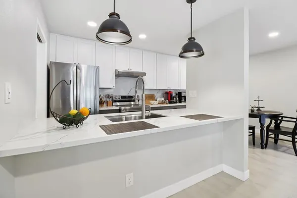 a kitchen with stainless steel appliances a sink a stove a refrigerator and cabinets