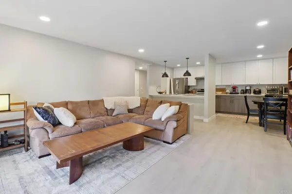 a living room with furniture and kitchen view