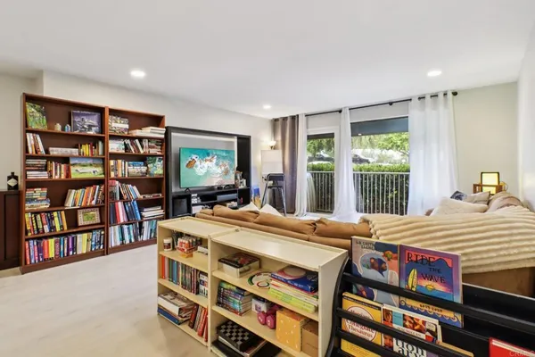 a room with a bed a book shelf and a window