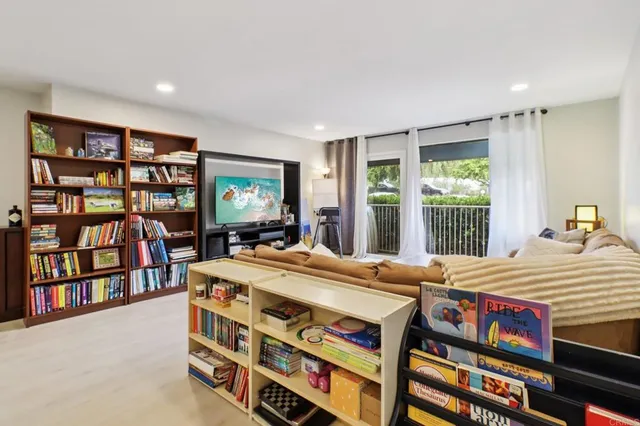 a room with a bed a book shelf and a window