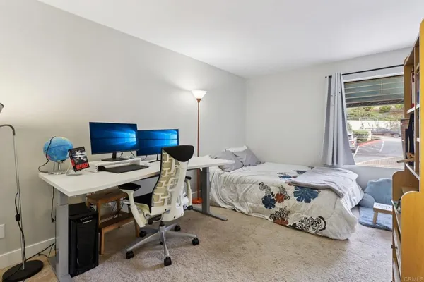 a bedroom with bed and a desk