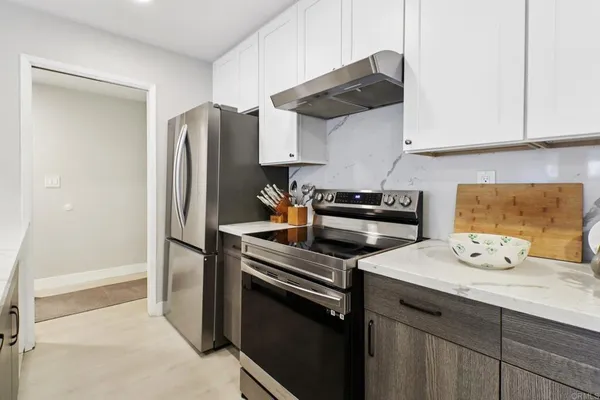 a kitchen with stainless steel appliances a stove a refrigerator and cabinets