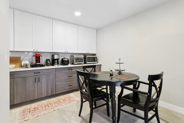a kitchen with a dining table chairs and cabinets