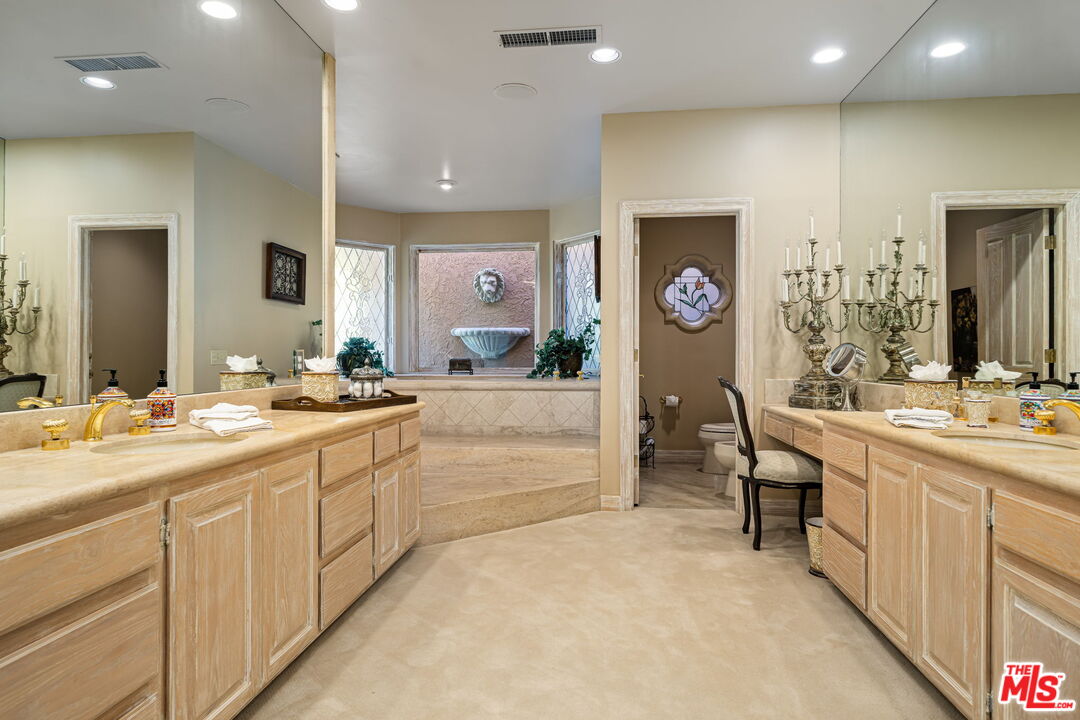 71150 North Thunderbird Terrace Rancho Mirage, CA 92270 - Photo 44 of 75 a spacious bathroom with a double vanity sink and a mirror