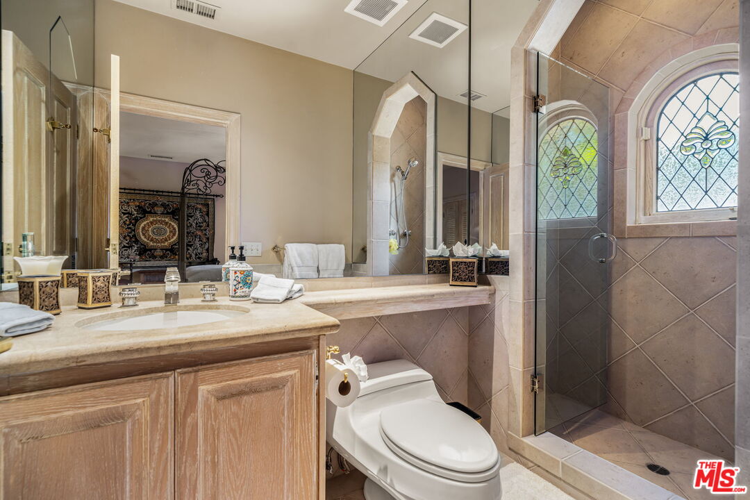 71150 North Thunderbird Terrace Rancho Mirage, CA 92270 - Photo 54 of 75 a bathroom with a granite countertop toilet a sink and a mirror