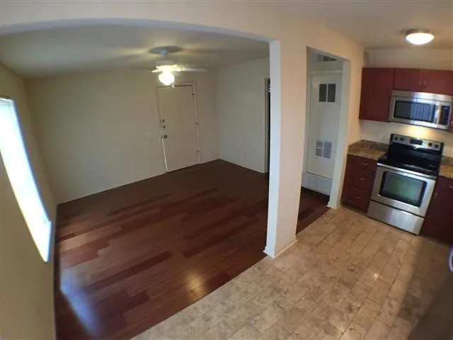 a view of empty room with wooden floor