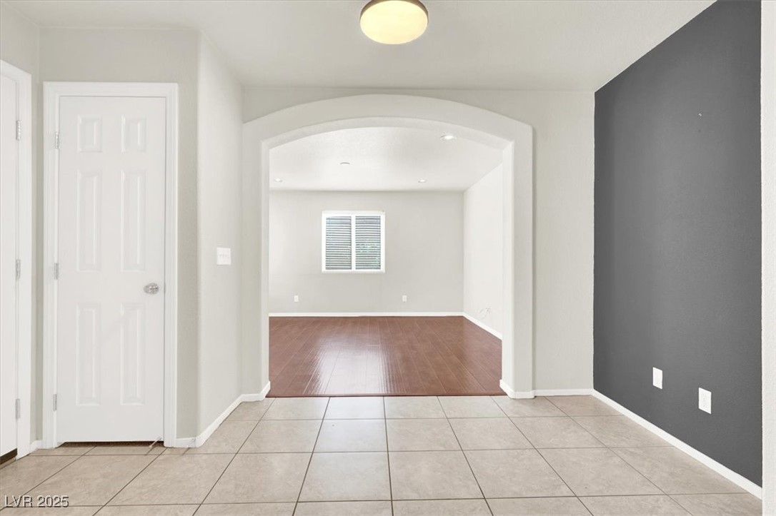 6909 Graceful Cloud Avenue Las Vegas, NV 89122 - Photo 11 of 33 Spare room featuring arched walkways and light tile patterned floors