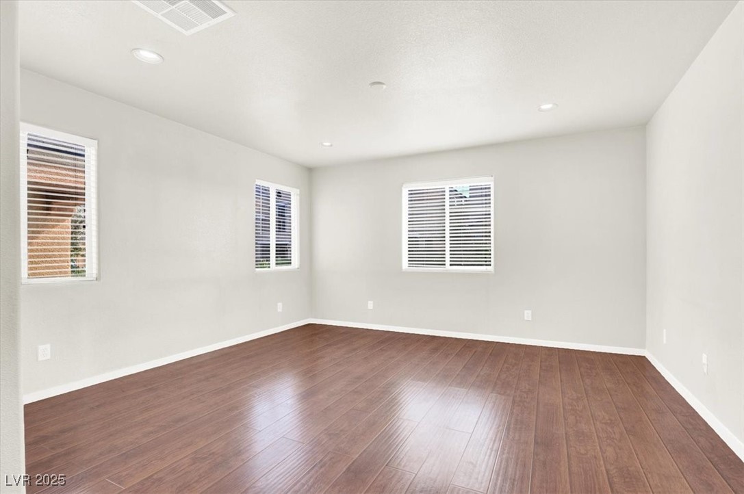 6909 Graceful Cloud Avenue Las Vegas, NV 89122 - Photo 12 of 33 Empty room with dark wood-style flooring and recessed lighting
