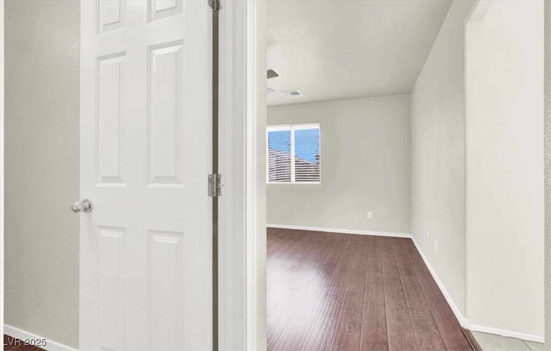 6909 Graceful Cloud Avenue Las Vegas, NV 89122 - Photo 19 of 33 Hallway with baseboards and dark wood-type flooring