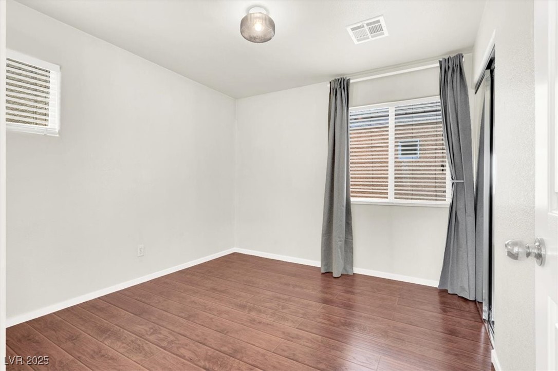 6909 Graceful Cloud Avenue Las Vegas, NV 89122 - Photo 29 of 33 Unfurnished room featuring dark wood-style floors and baseboards