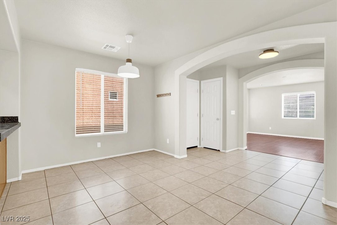 6909 Graceful Cloud Avenue Las Vegas, NV 89122 - Photo 10 of 33 Unfurnished dining area featuring arched walkways and light tile patterned floors