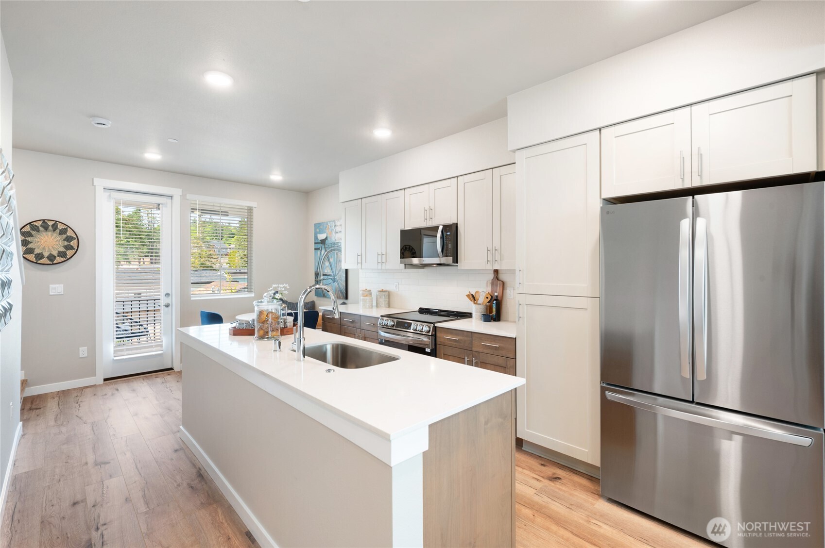 1322 194th Street Southeast, Unit D5 Bothell, WA 98012 - Photo 6 of 13 a kitchen with stainless steel appliances a refrigerator a sink a stove a microwave a center island and furniture