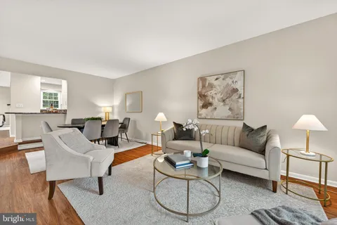 a living room with furniture a rug and a table