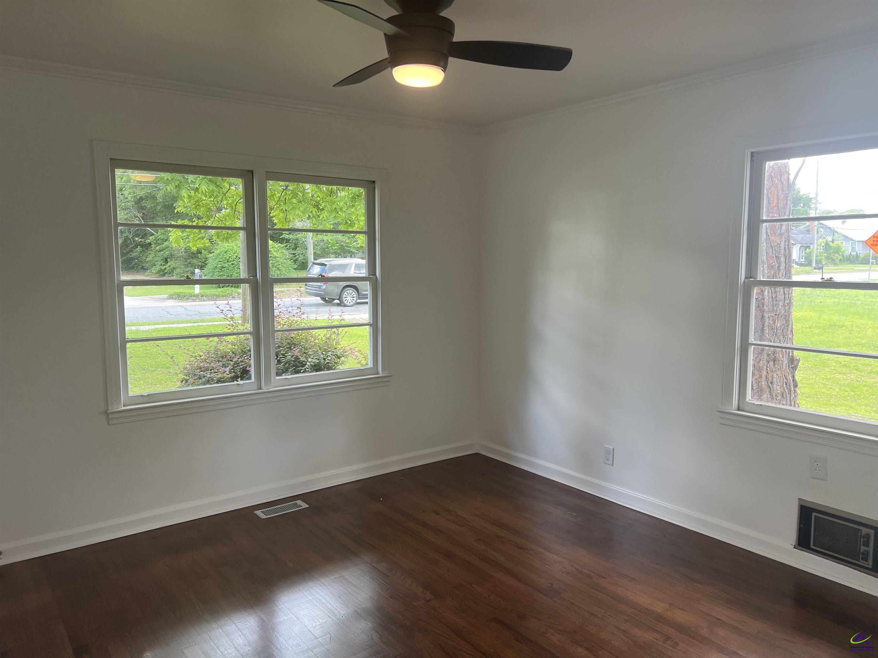 145 South 2nd Street Cochran, GA 31014 - Photo 21 of 24 a view of an empty room with wooden floor and a window