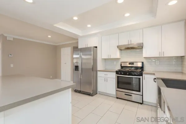 a kitchen with stainless steel appliances granite countertop a refrigerator and a stove top oven