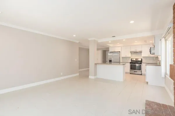 a view of kitchen with kitchen island white cabinets and refrigerator