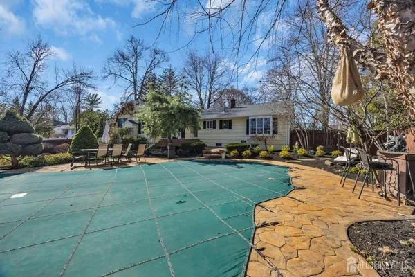 a view of a patio with table and chairs potted plants and large tree