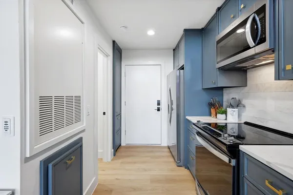 a kitchen with stainless steel appliances a stove a microwave and cabinets