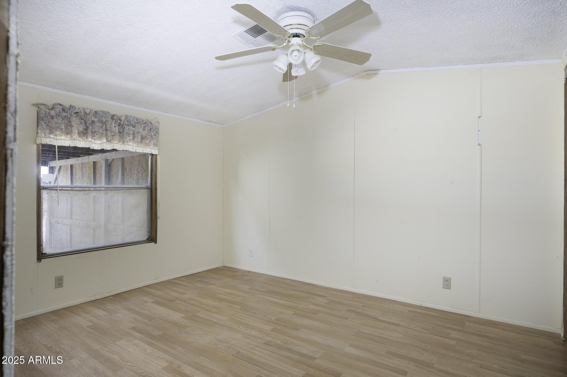 9505 West Milligan Road Arizona City, AZ 85123 - Photo 21 of 45 an empty room with wooden floor fan and windows