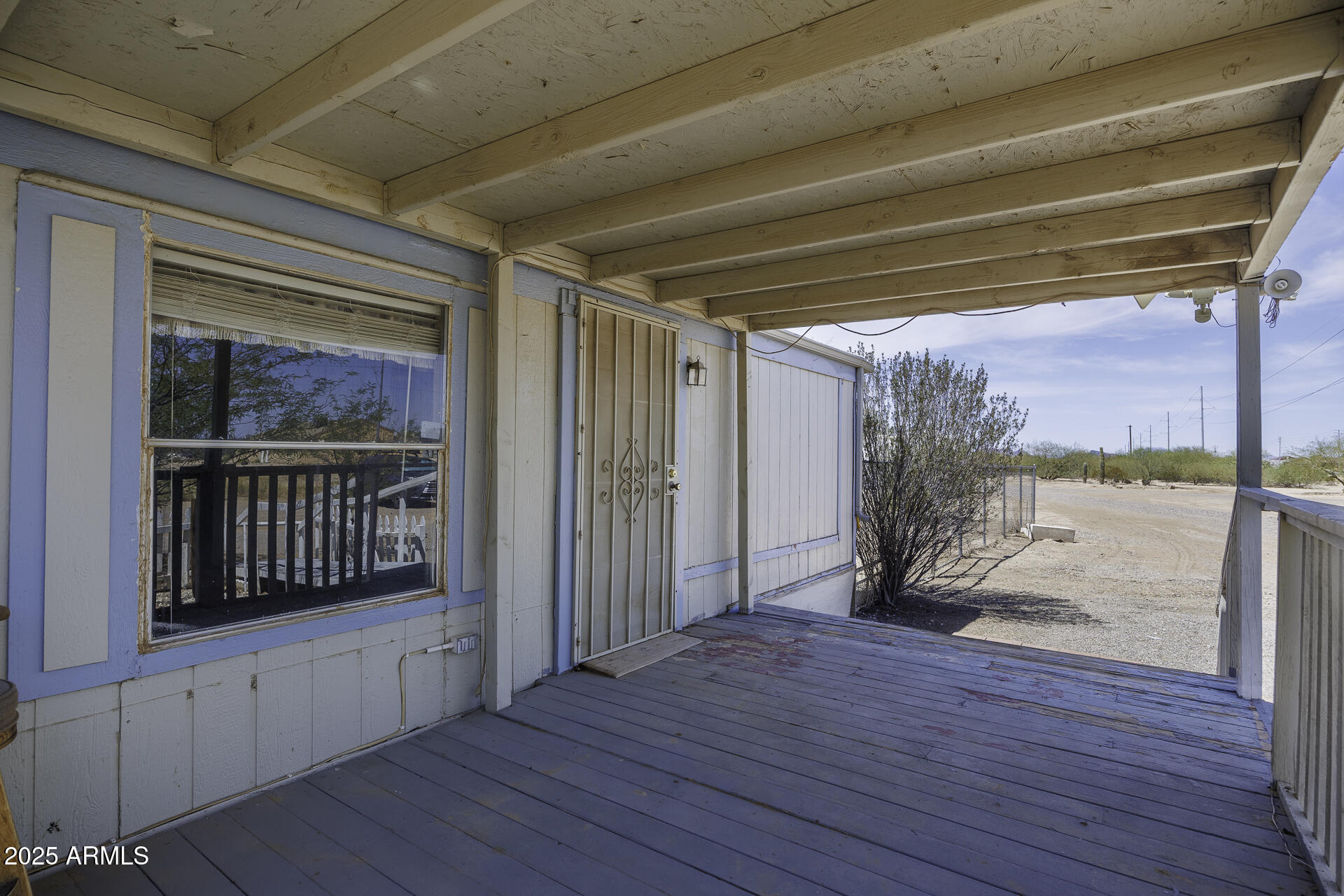 9505 West Milligan Road Arizona City, AZ 85123 - Photo 8 of 45 a view of an empty room with wooden floor and a window