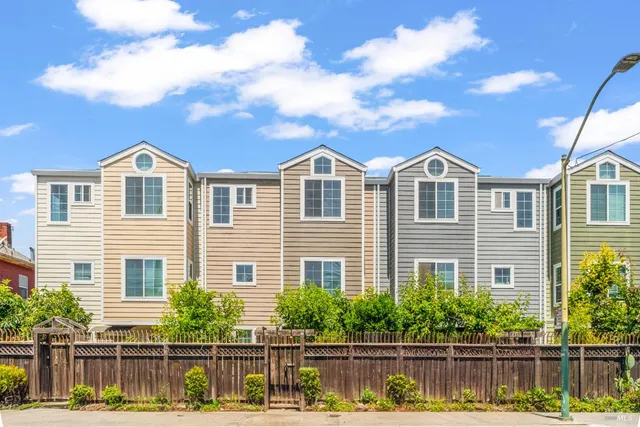a front view of a house with a large window and potted plants