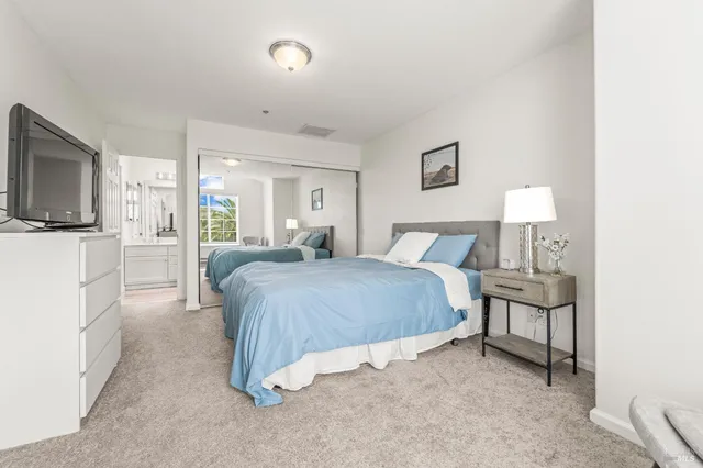 a spacious bedroom with a bed and a flat screen tv