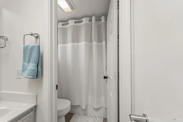 a bathroom with a shower curtain and a toilet