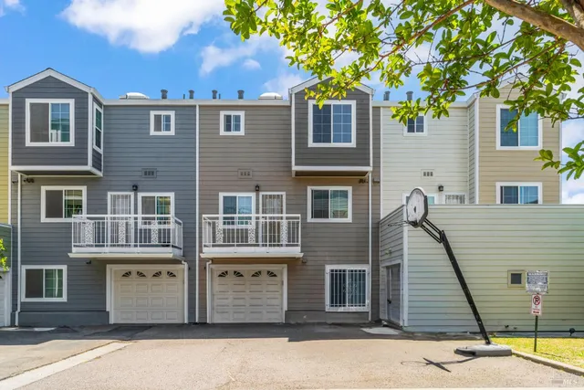 a front view of a house with a tree