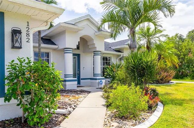 a view of a dining room and livingroom with furniture wooden floor a chandelier
