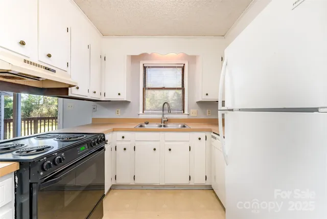 a kitchen with granite countertop a sink stove and cabinets