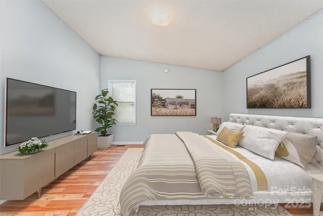 a bedroom with a large bed and a flat screen tv