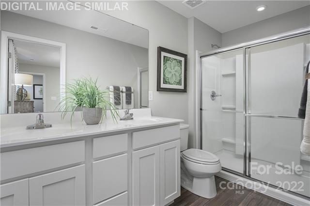 117 Hackamore Road, Unit 208 Troutman, NC 28166 - Photo 12 of 17 a bathroom with a toilet sink vanity granite and shower